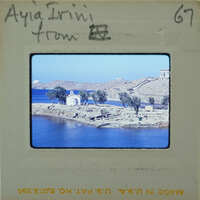 Picture of a scenic coastal landscape with blue water and green trees.