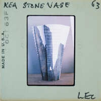 A photograph of a stone vase with jagged edges on a table.