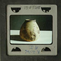 Ancient ceramic vase with intricate designs on display.