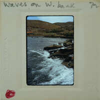 Photo of a rocky coastline with waves crashing against the shore.