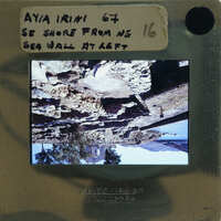 Upside-down photograph of a rocky coastline on a film strip with handwritten notes.