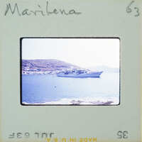 Photo of a boat on water with mountains in the background, taken from a vintage Polaroid camera.