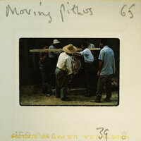 A vintage photograph of men working on a moving pit, with handwritten notes and numbers indicating its historical significance.