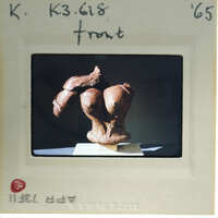 Terracotta figurine torso from front.