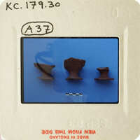 Photograph of ancient pottery pieces on blue background with white markings and labels.