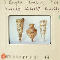 Three ancient clay vases with intricate designs displayed on a white surface.