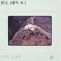 Aerial photograph of a mountainous landscape with a road and vegetation.