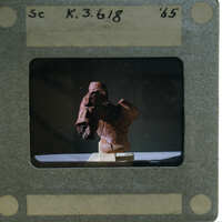 Terracotta figurine torso from side.