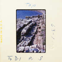 A photograph showing an ancient stone wall along a rocky coastline.