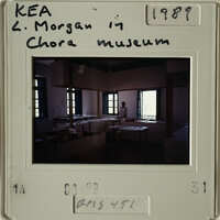 The image shows an interior room with desks and books, possibly a classroom setting from the past.