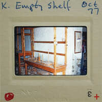 A photograph of a workshop with empty wooden shelves and workbenches.