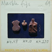 An old photograph with three marble figurines on a blue surface.