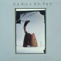 An image of a wooden sculpture with an abstract design, photographed against a white background.