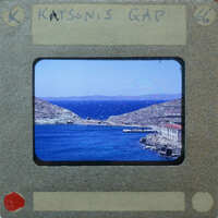 A vintage film strip with a scenic view of the ocean and mountains.