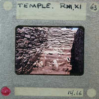 A photograph of a stone structure, possibly ruins, with an old-fashioned film strip border.