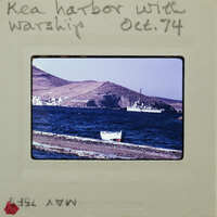 A vintage photograph of a harbor with boats and mountains in the background, dated October 1974.