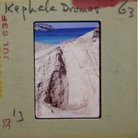 A slide of a rocky coastline with water and blue sky.