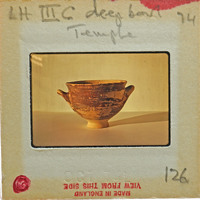 Reassembled deep bowl with two handles in profile.