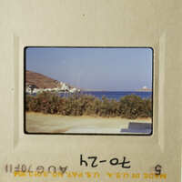 A vintage photo capturing a serene beach scene with clear blue skies and calm waters.