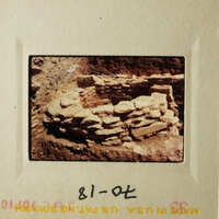 The image shows an ancient stone structure, possibly a wall or ruins, with a focus on its historical significance and architectural details.