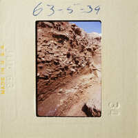 A photograph of an ancient wall with layers of stone and dirt.