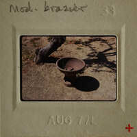 Ancient clay pot on ground with tree shadow.