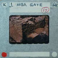 An old photograph of a stone structure with a label and numbers on it, possibly from a film strip.