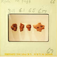 Photo of three small, brown figurines on a white surface.