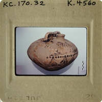 Ancient vase with intricate patterns displayed on a light surface.