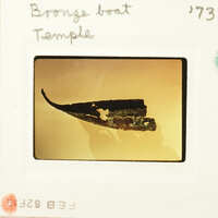 A photograph of an ancient boat model on display.