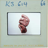 Small clay sculpture of a face with exaggerated features.