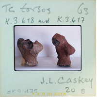 Two small sculptures on a table with labels.