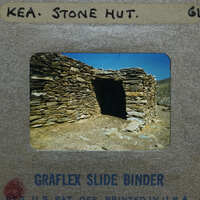 A photograph of a stone hut on a slide.