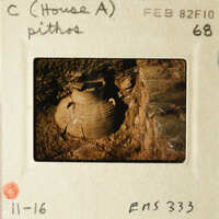 Ancient pottery artifact with visible cracks and dirt, photographed on an old film slide.