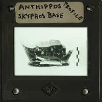 Old photograph of an ancient artifact, possibly a piece of pottery with visible cracks and fragments.