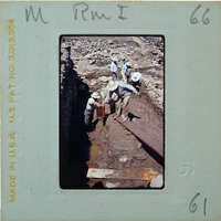 Workers excavating a site with shovels and wheelbarrows.