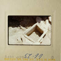 Old photo of an empty wooden box with a dirt background.