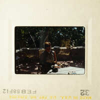 A person sitting at a table on a patio.