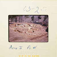 Ancient ruins with stone foundations and scattered debris, possibly from an archaeological site.