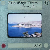 A vintage photograph of a coastal landscape with mountains and water.