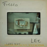 A photograph of a broken wall painting fragment in a museum display case.