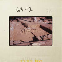 Archaeological excavation site with exposed stone structures and layers of earth.