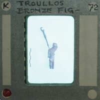 A small figurine of a person holding a hammer, displayed on a piece of paper with handwritten notes.