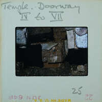 Marble step and doorway in muddy floor of building interior.