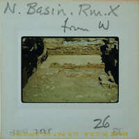 A photograph of an archaeological site with ancient ruins and a handwritten note on the back.