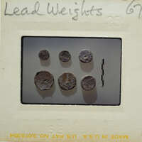 Image of circular lead weights on a surface.