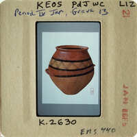 This is an image of a clay pot with a patterned design, displayed on a card with printed information about its origin and identification number.