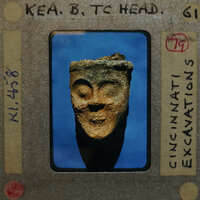 Fragment of broken terracotta head from front; figurine K1.458.