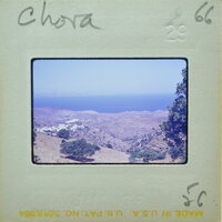 A vintage photograph of a coastal landscape with hills and trees, taken from a high vantage point.