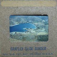 An old photograph of a lake and mountains.